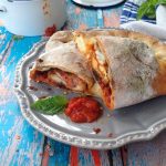 Chicken Stuffed Calzone with Arrabiata Sauce on a Rustic Table