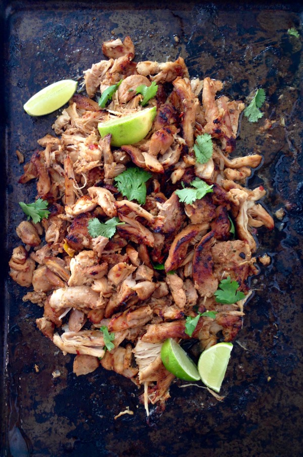 Black cookie sheet with shredded chicken carnitas 