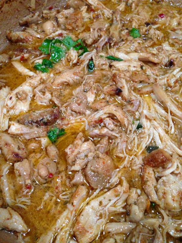 Pot of chicken carnitas cooking in gravy