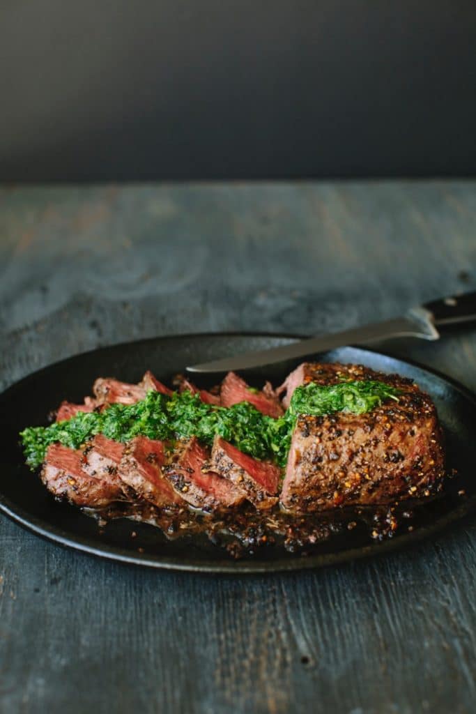 Sirloin Steak in a Cast Iron Skillet drizzled with Chimichurri Sauce