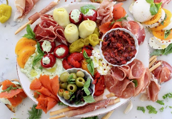 White Marble Platter of Italian Antipasto: cured meats, marinated vegetables, cheese and crostini