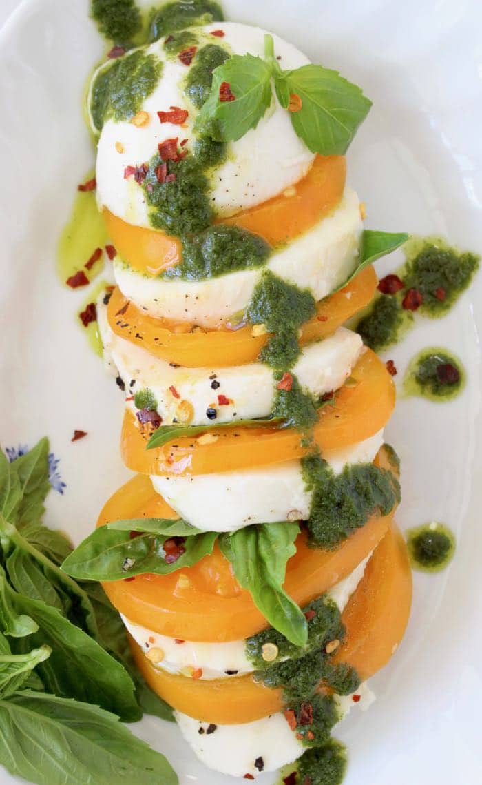 Platter of heirloom tomatoes and mozzarella drizzled with homemade basil oil.