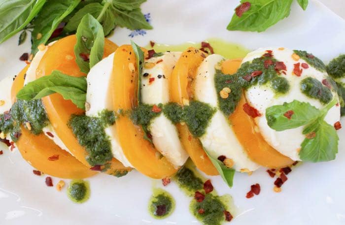 Basil Oil Drizzled over Slices of Yellow Heirloom Tomatoes and Mozzarella di Bufala