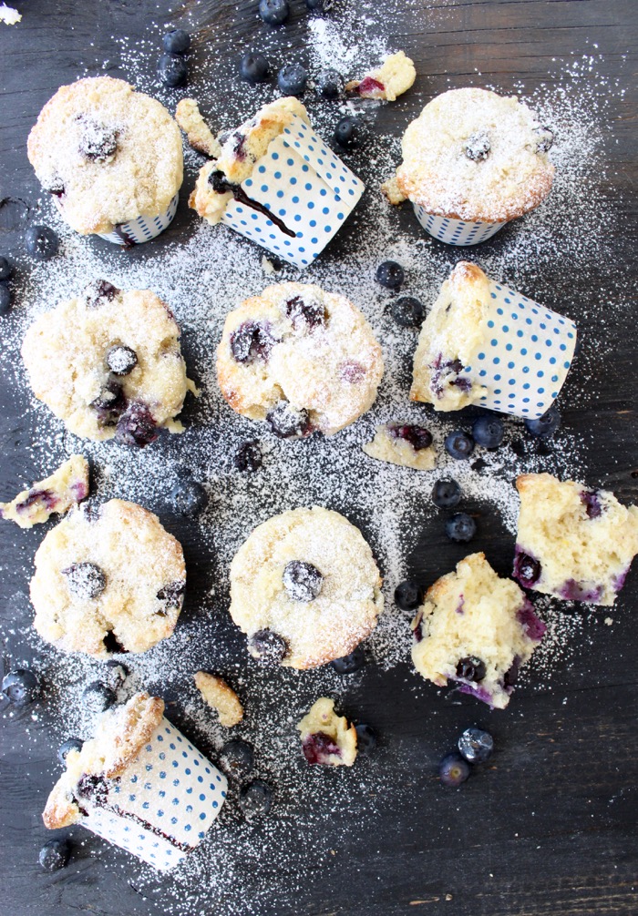 blueberry and ricotta muffins in polka dot muffin cups on a wooden table