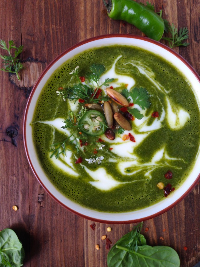 Bowl of Vegetarian Kale Soup with a Swirl of Cream on a Rustic Table