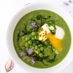 bowl of healthy leek soup with chive oil and green peas
