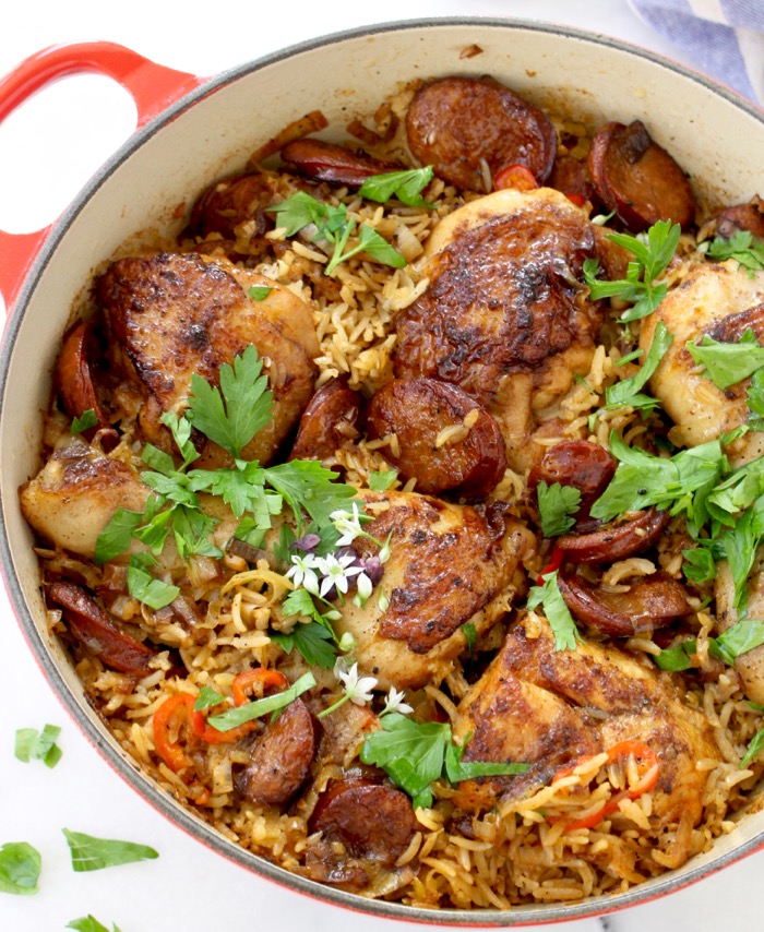 Red pot with baked chicken and brown rice, andouille sausage, leeks and with parsley