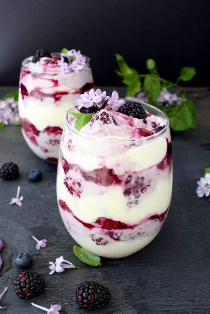 Glasses of Berry Tiramisu Trifle with Blackberries and Lilac Blossoms